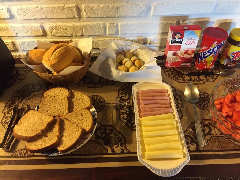 Mesa de café da manhã com pães, frios e frutas